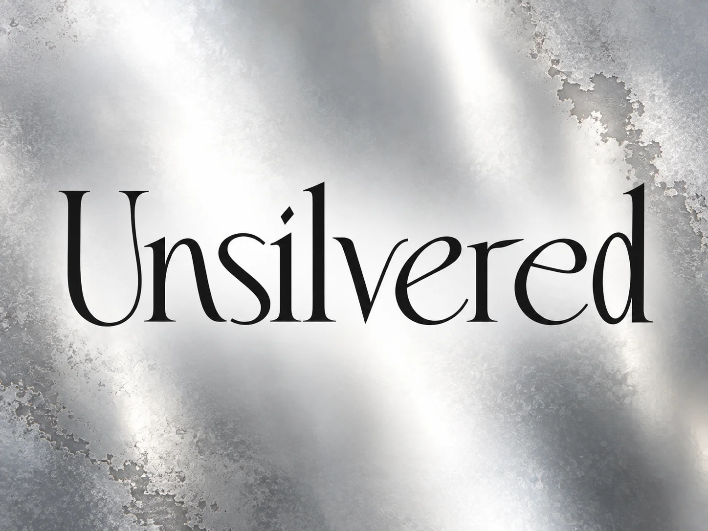 Unsilvered title artwork on a silver mirror surface